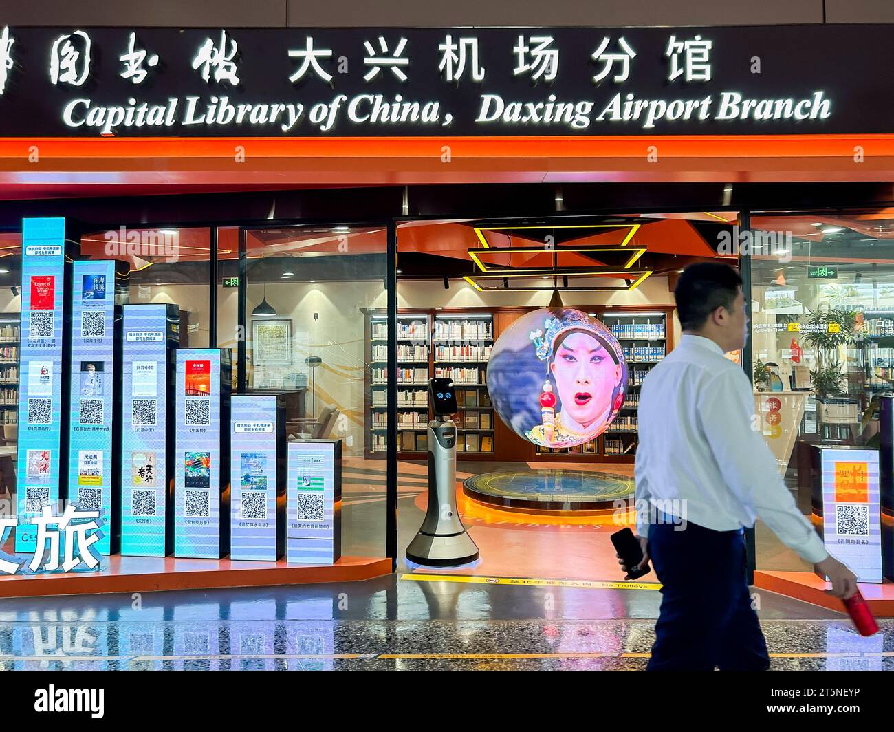 Pechino, Cina, uomo che cammina davanti, vista interna dell'aeroporto internazionale di Pechino Daxing, all'interno della libreria cinese, 'Biblioteca della capitale della Cina', insegna Foto Stock