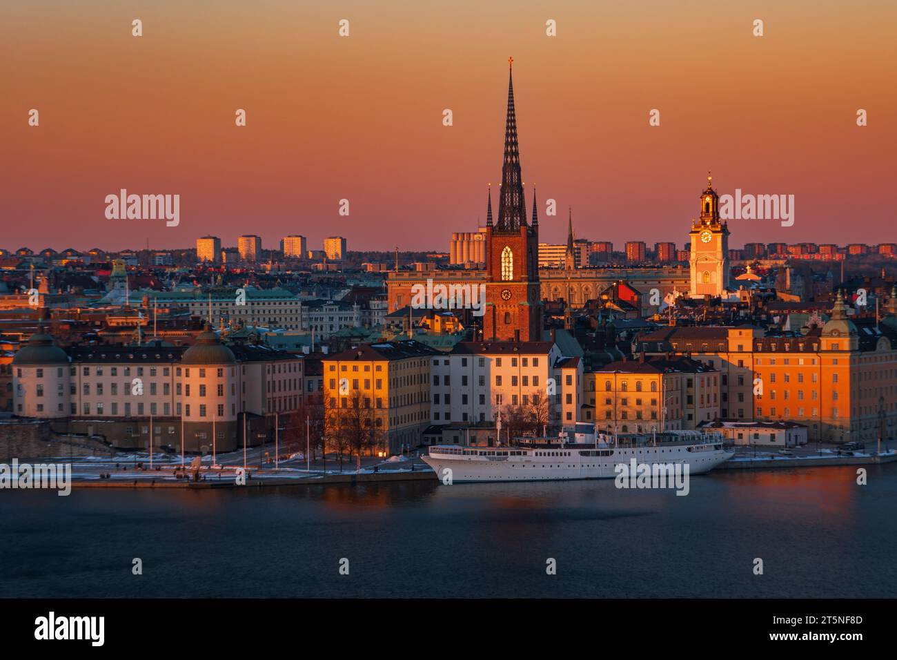 Stoccolma, la città vecchia, al tramonto. Riddarholmen, la chiesa tedesca, in centro. Toni del cielo arancione e rosso. Foto Stock