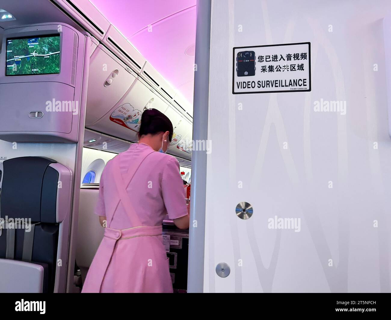Shanghai, Cina, veduta dell'interno dell'aereo della compagnia aerea cinese, cartello "Video Surveillance", china Young Woman "Juneyao Air", (Boeing 787-9 Jet) hostess che lavora Foto Stock