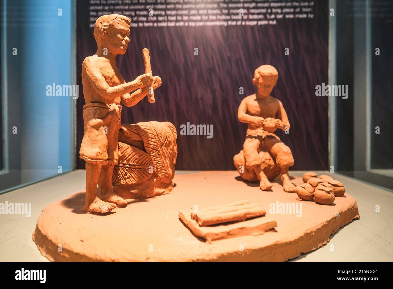Un'esposizione di un paio di lavoratori tradizionali, fatti in argilla. Presso la storia locale, il patrimonio culturale e il museo della cultura nella piccola città di Nonthaburi, appena a nord Foto Stock