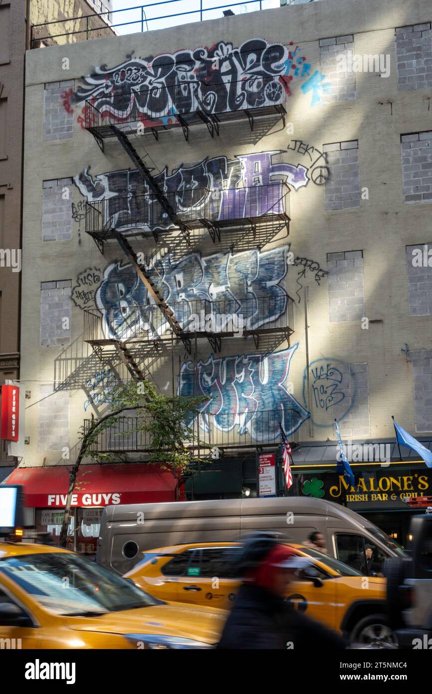 I graffiti colorati segnano la facciata dell'edificio a Midtown Manhattan, 2023, New York City, Stati Uniti Foto Stock