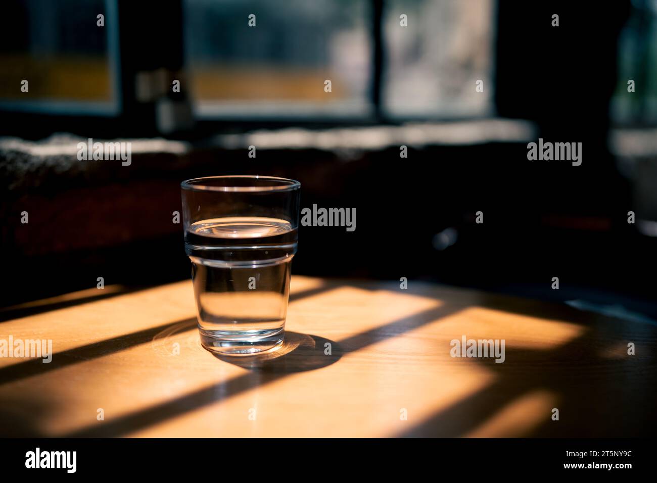 Una tazza d'acqua su un tavolo di legno nel bar, foto di magazzino Foto Stock