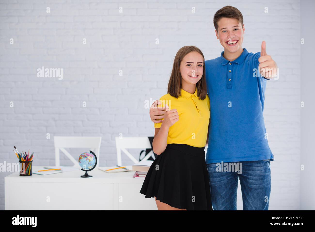Adolescenti che gestiscono il pollice verso l'alto Foto Stock