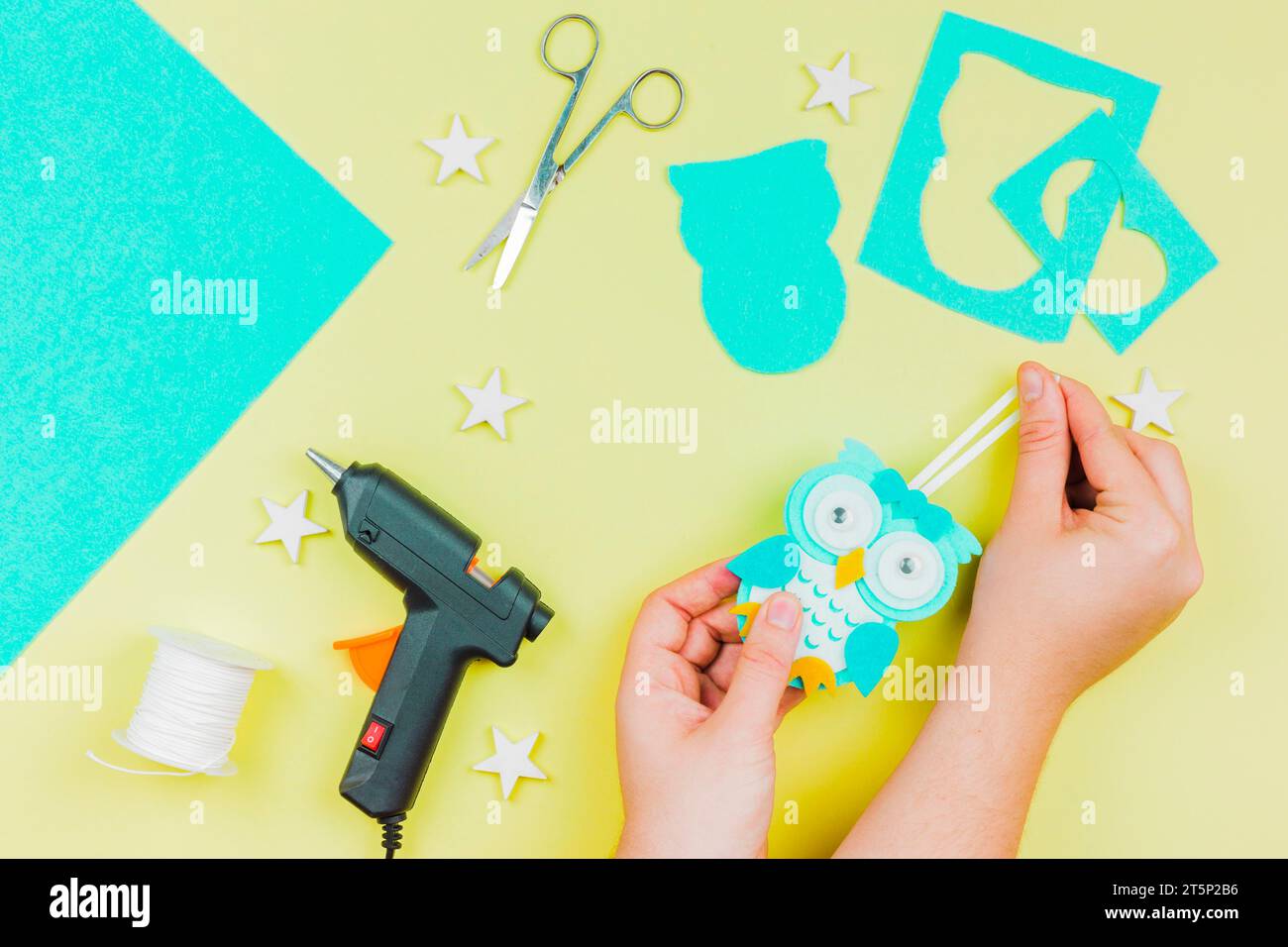 Mano di donna che fa appendere carta da parati gufo sfondo colorato Foto Stock