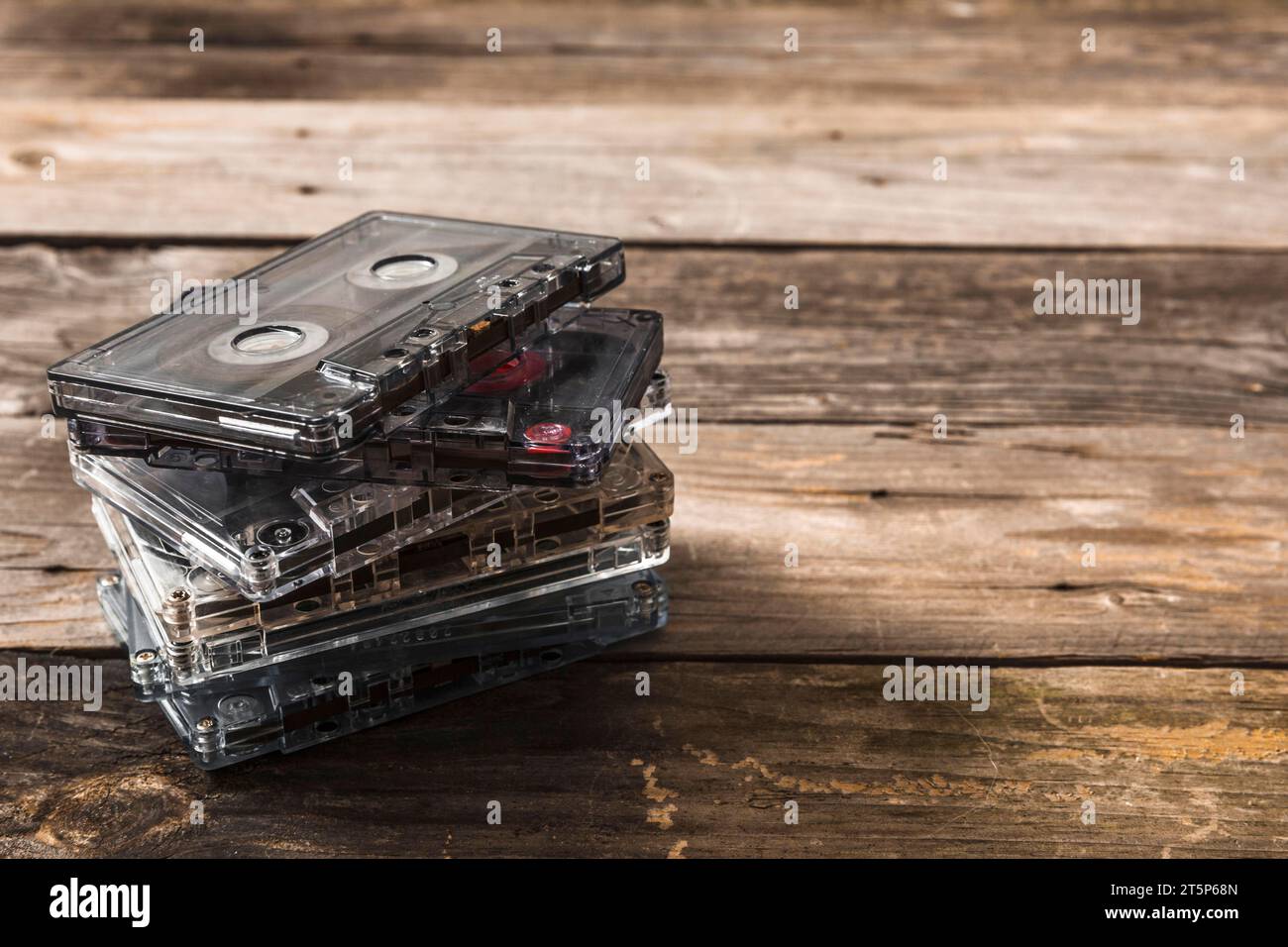 Impilare nastri a cassetta trasparenti con sfondo in legno Foto Stock