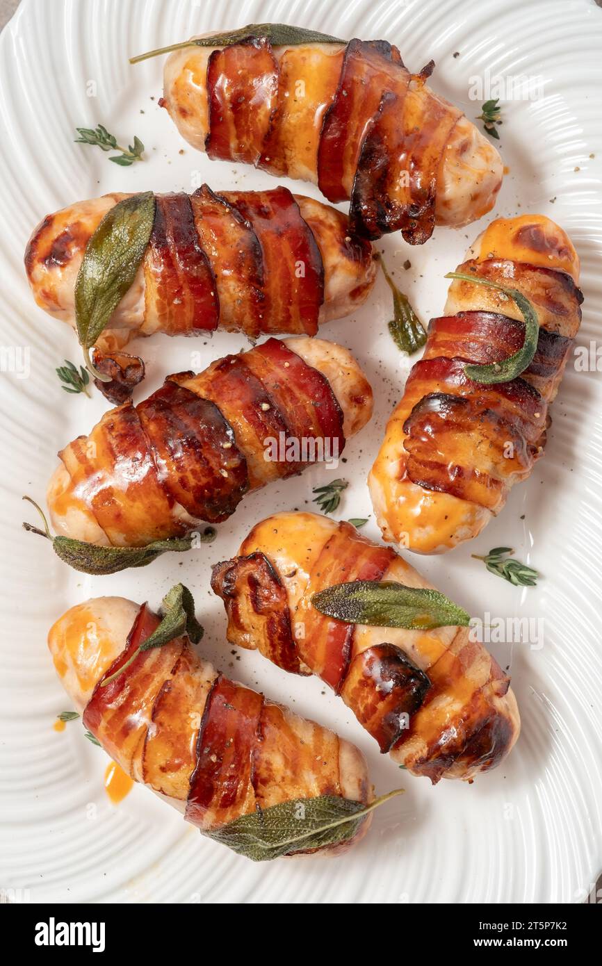 Maiali di Natale in coperte, salsicce avvolte in pancetta con foglie di salvia Foto Stock