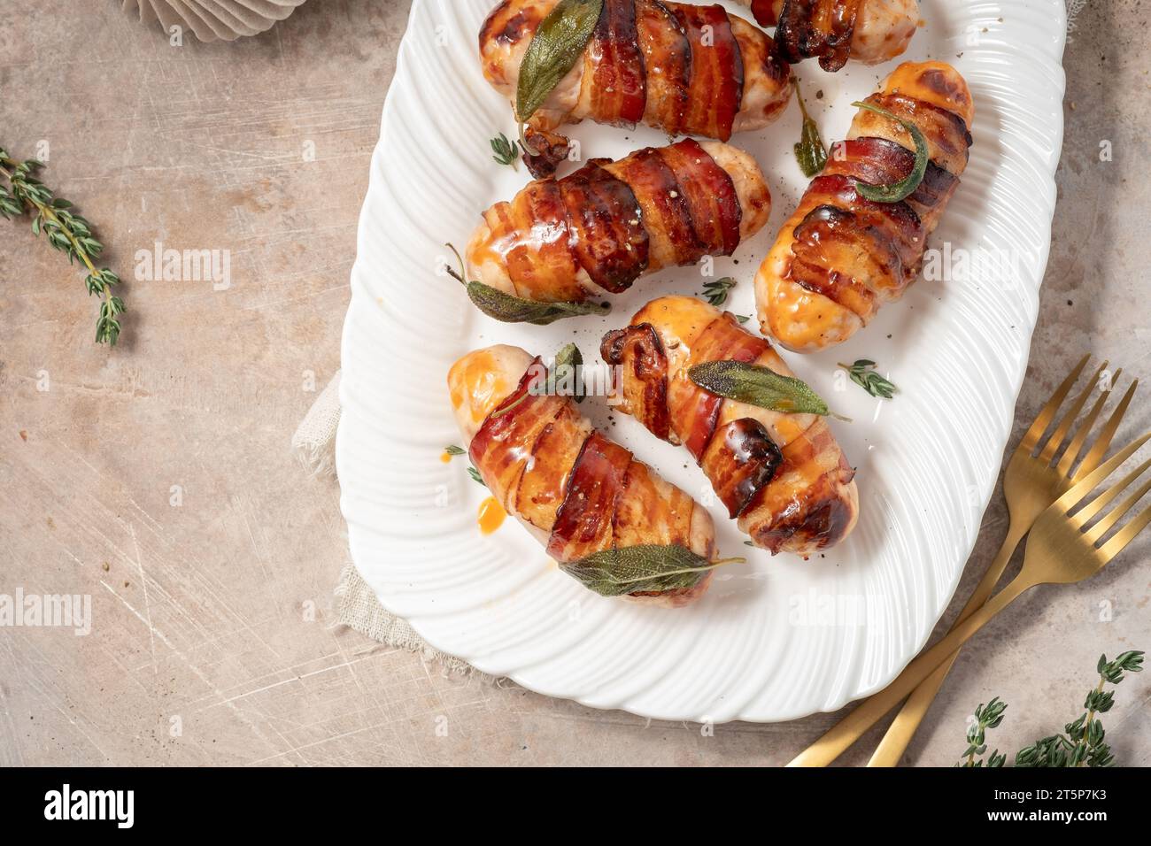 Maiali di Natale in coperte, salsicce avvolte in pancetta con foglie di salvia Foto Stock