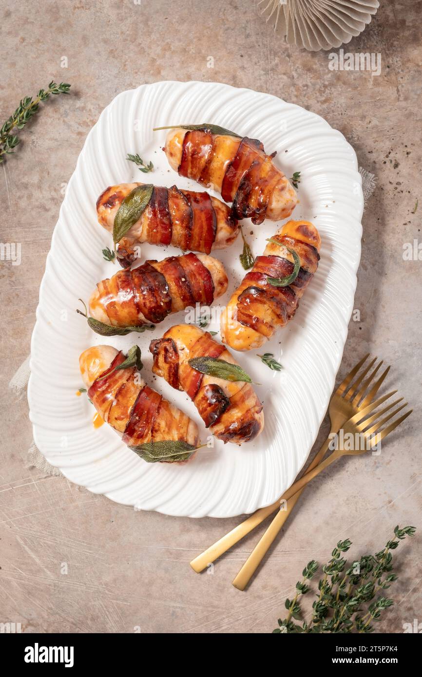 Maiali di Natale in coperte, salsicce avvolte in pancetta con foglie di salvia Foto Stock