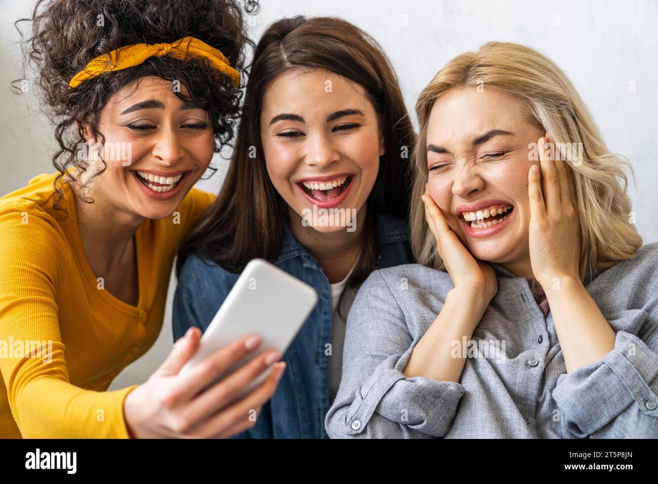 Vista frontale tre donne felici sorridenti che scattano selfie Foto Stock