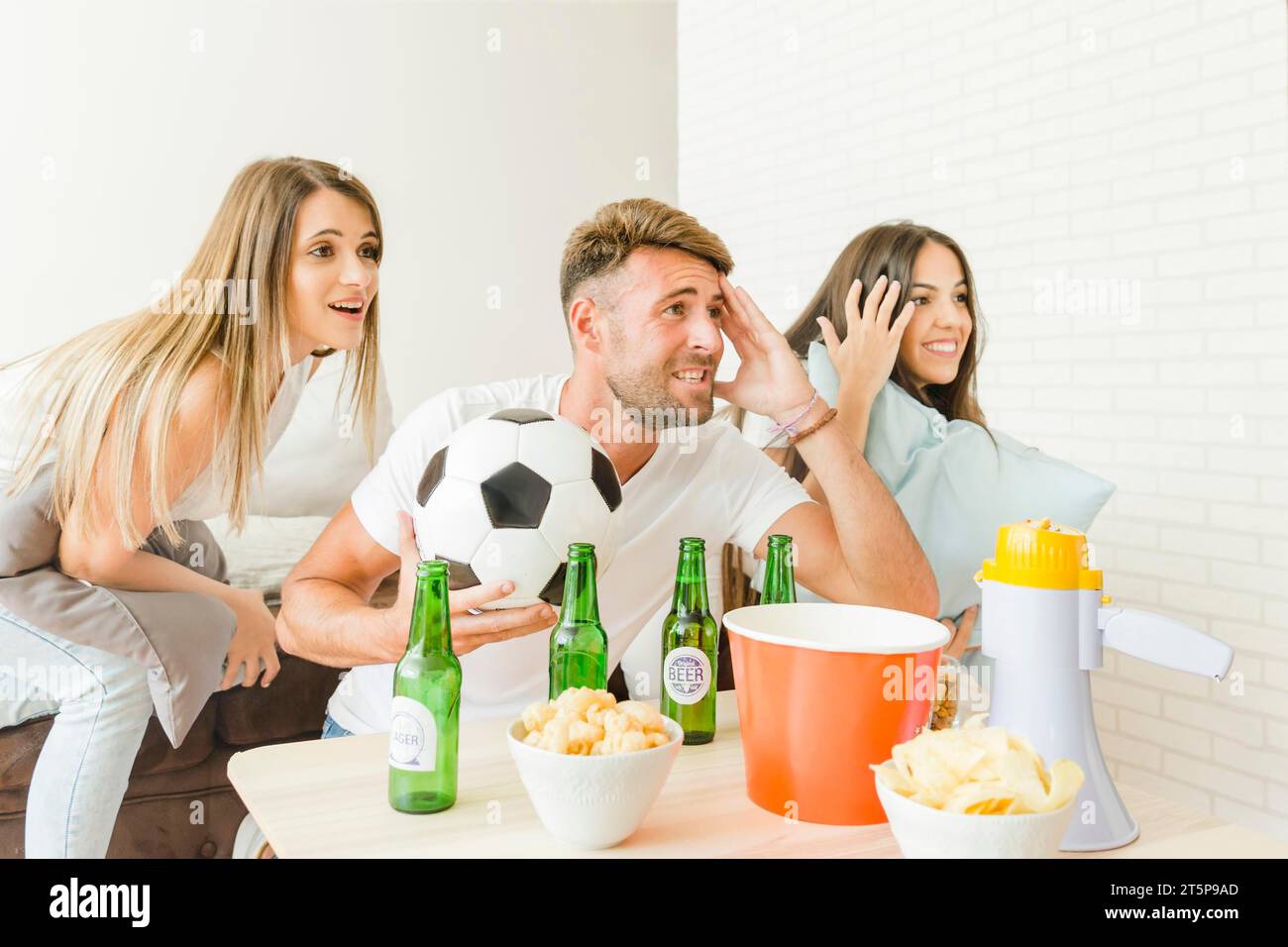 Gente che fa il tifo per guardare la partita di calcio a casa Foto Stock