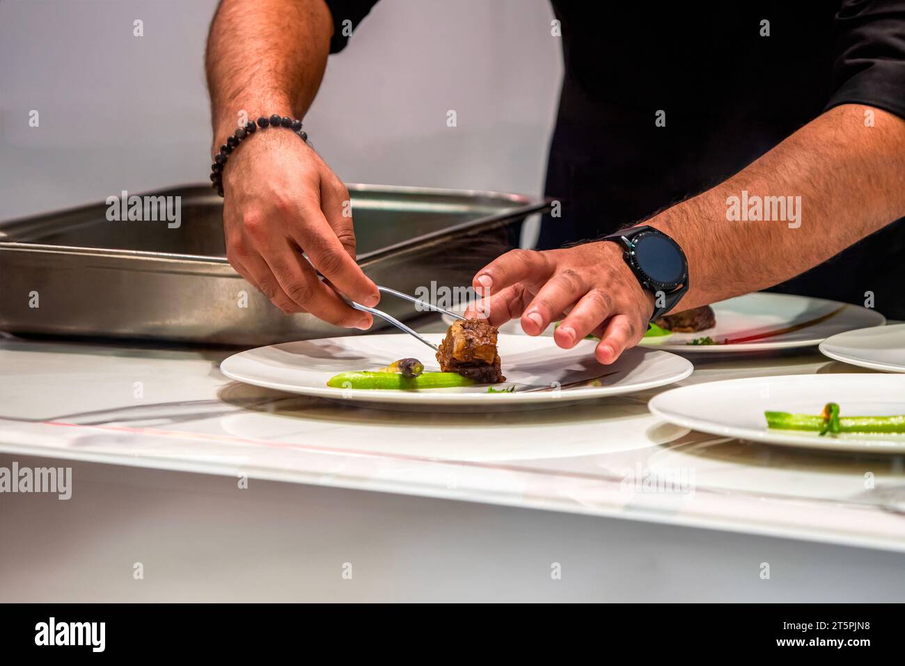 Lo chef prepara un piatto di carne. Foto Stock