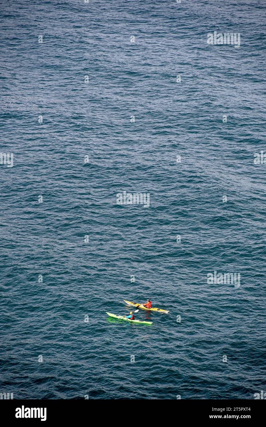 Due persone in canoa al largo della costa della Cornovaglia, Inghilterra, Regno Unito Foto Stock