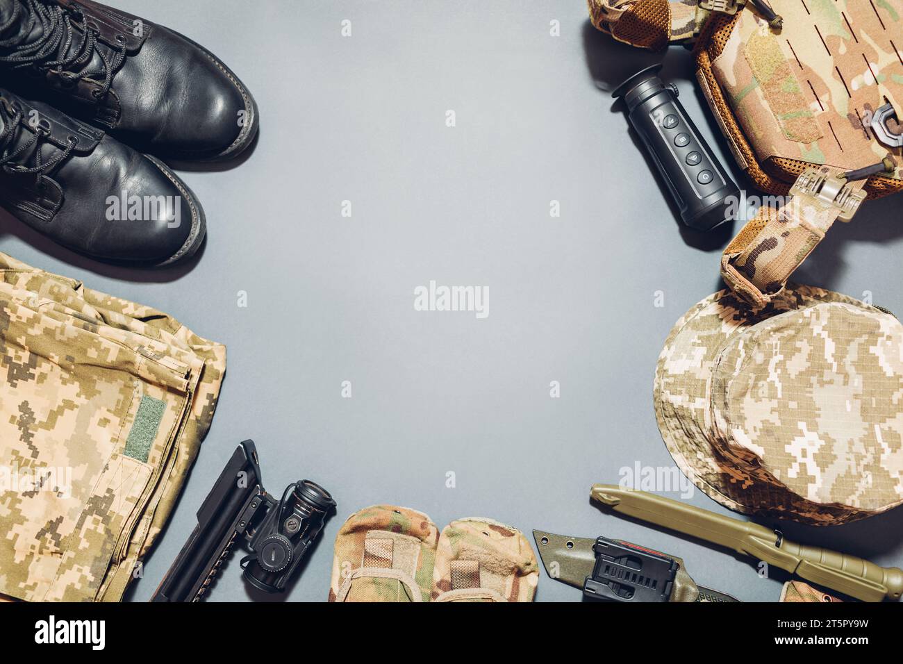 L'equipaggiamento militare piatto si trova sullo sfondo. Abbigliamento uniforme tattico militare, giubbotto antiproiettile, coltelli, termocamera, vista ottica per fucile. Piano, spazio Foto Stock