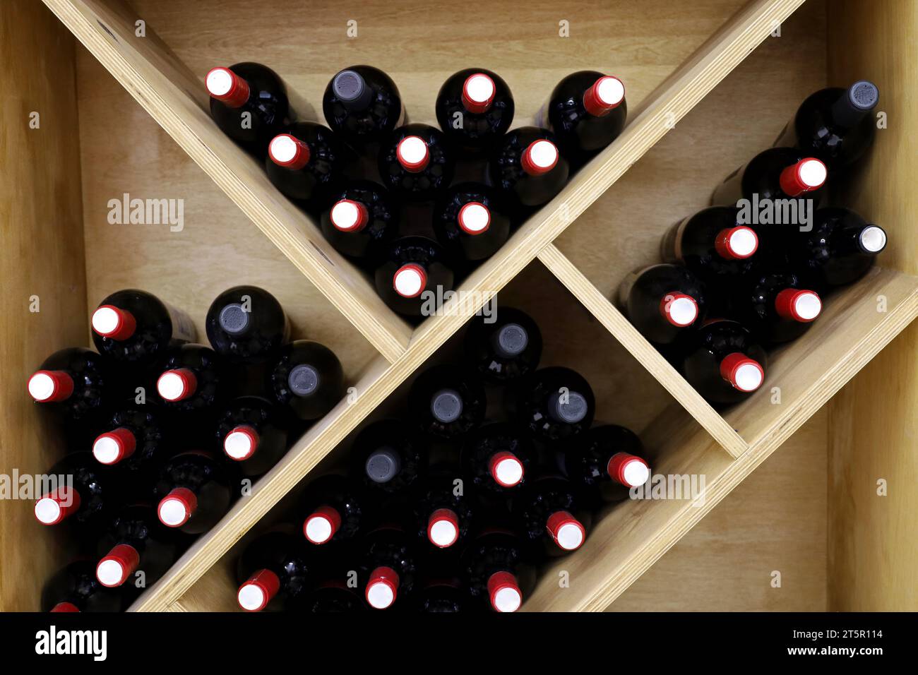 Bottiglie di vino in un portabottiglie di legno. Negozio di alcolici, vino bianco e rosso Foto Stock