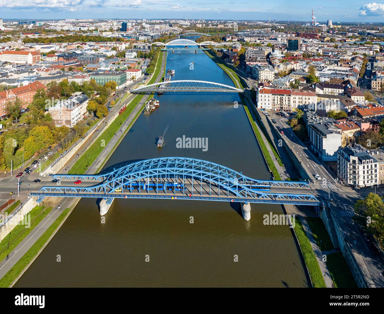 Cracovia, Polonia. 5 ponti sul fiume Vistola. Vista aerea. Ponte ad arco blu Pilsudski con tram e tram di fronte. Quindi passerella e bicicletta Foto Stock