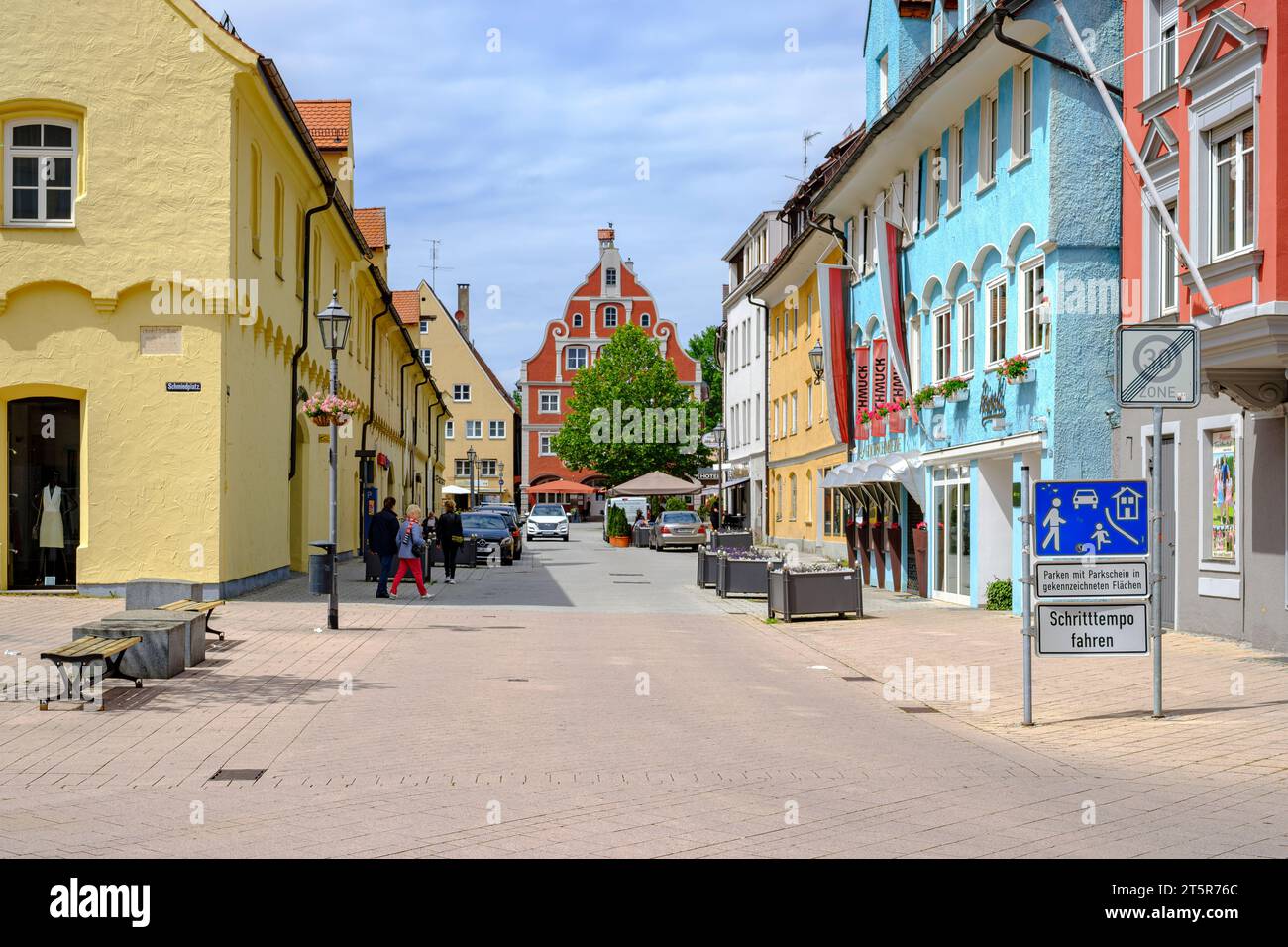 Vivace scena quotidiana di fronte a uno sfondo architettonico storico nella città vecchia di Memmingen, Svevia, Baviera, Germania. Foto Stock