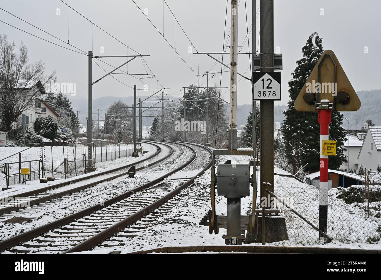 Binari ferroviari in inverno. In primo piano c'è la tecnologia per il passaggio a livello con rampa. Foto Stock