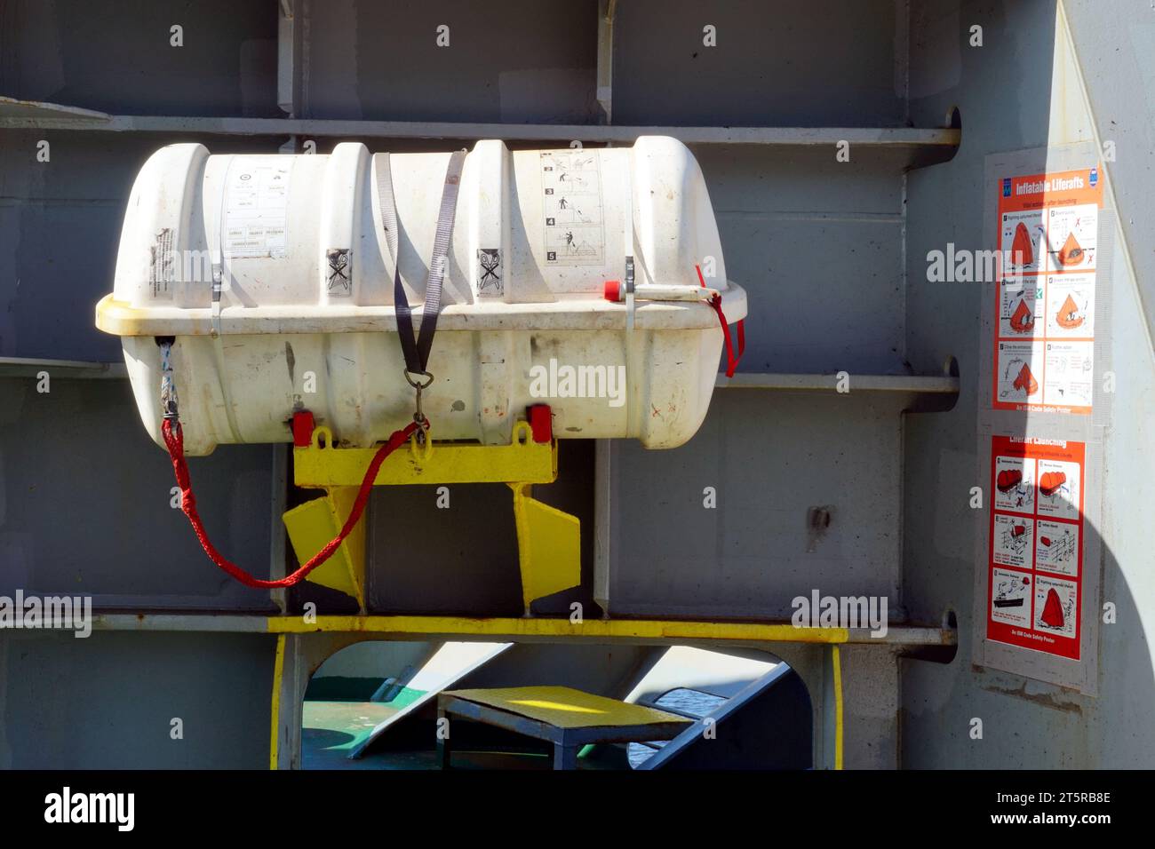 Zattera di salvataggio bianca senza rilascio idrostatico fissata nella stazione anteriore della nave container pronta per l'uso in situazioni di emergenza. Foto Stock