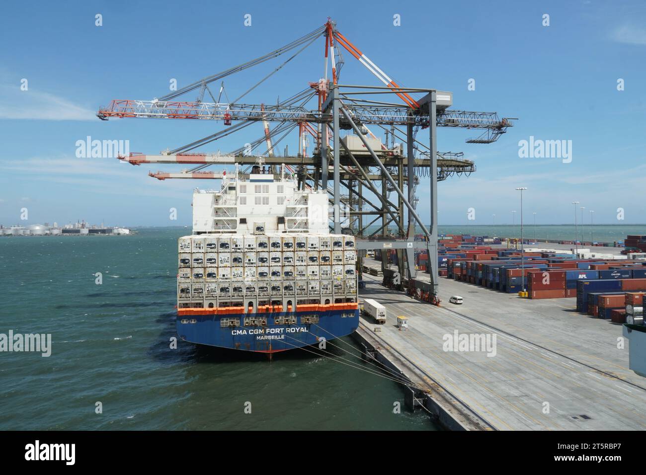 Le gru a cavalletto azionate da stevedores caricano e scaricano navi container con barriere anti-pirateria. Foto Stock
