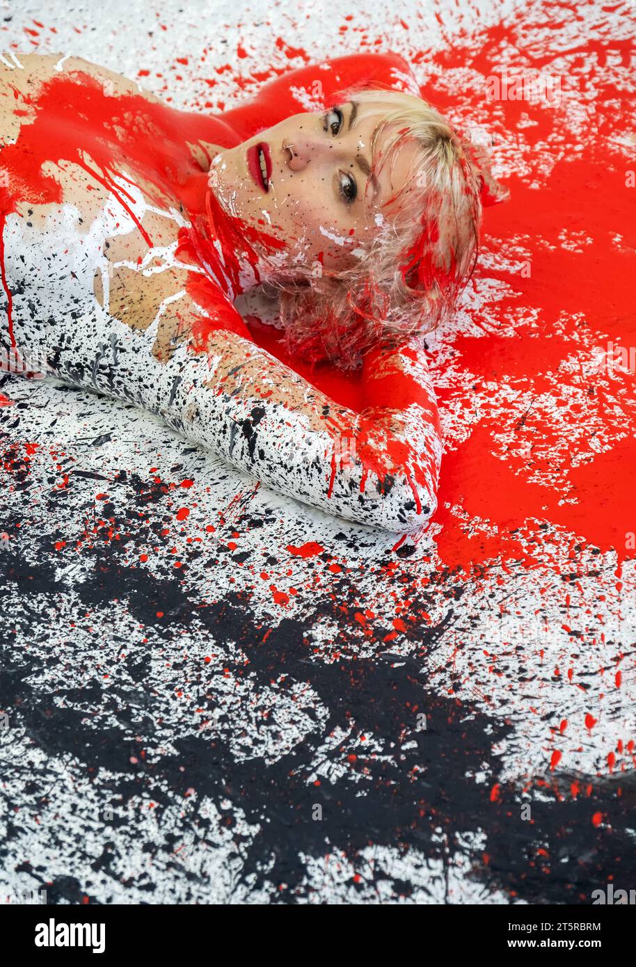 Ritratto e parte superiore del corpo di una giovane donna bionda nuda sexy in bianco nero e rosso dipinto, si trova decorativo ed elegante sul pavimento dello Studio, spazio fotocopie Foto Stock