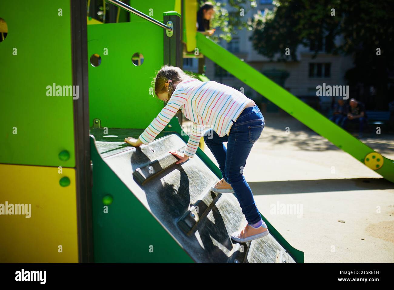 Adorabile bambina al parco giochi in una giornata di sole. Bambini in età prescolare che giocano all'aperto. Attività estive all'aperto per bambini Foto Stock