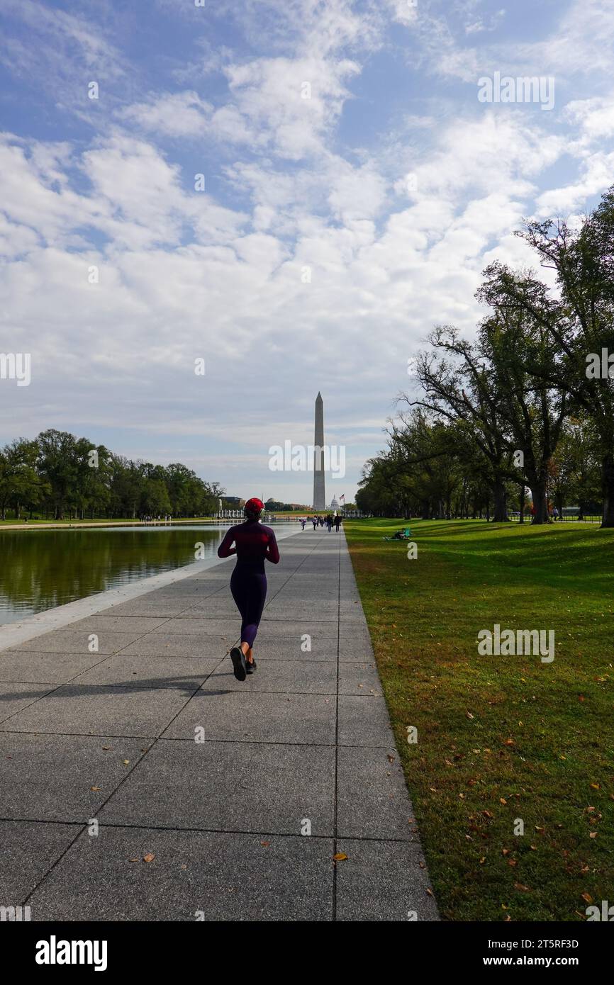 Donna che fa jogging davanti alla piscina riflettente del National Mall, Washington DC, USA. Foto Stock