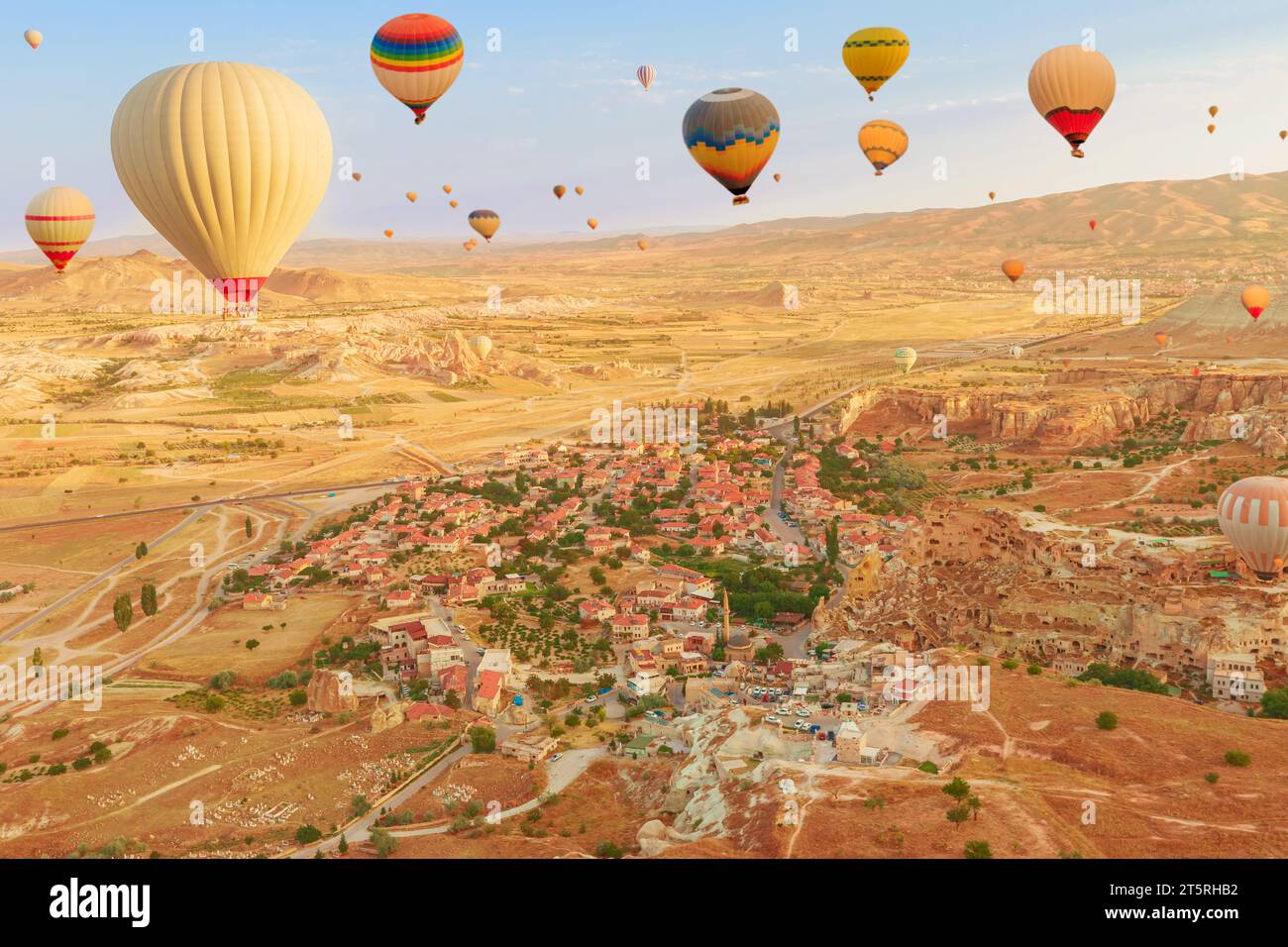 Mongolfiere nel vasto skyline della Cappadocia. Le brillanti sfumature dei palloncini catturano la luce del giorno, creando un'incantevole illuminazione sul surreale Foto Stock