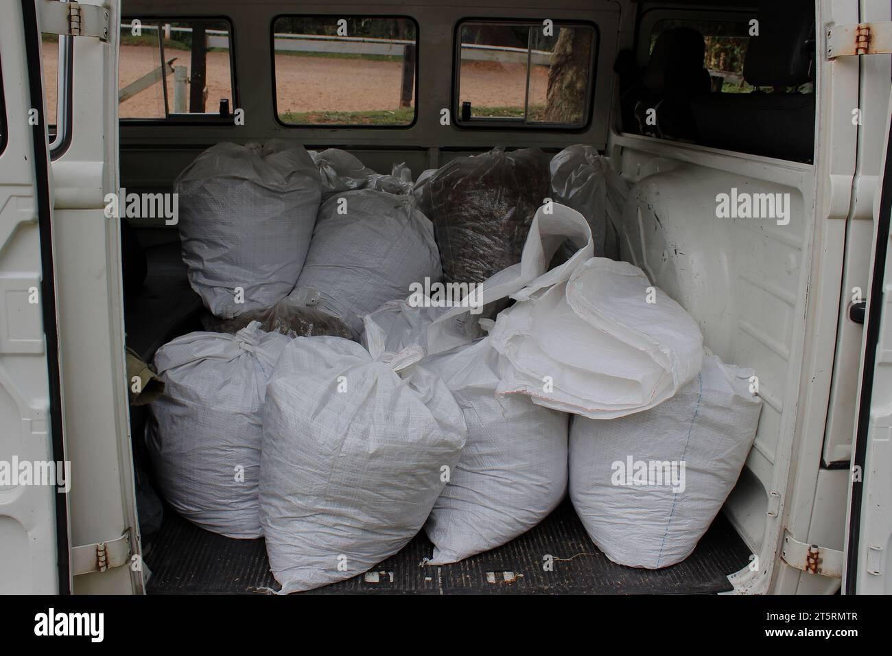 Input agricoli per giardinaggio e orto patch conservati in sacchetti di rafia bianca disposti nel letto di un veicolo di trasporto bianco d'epoca. Foto Stock