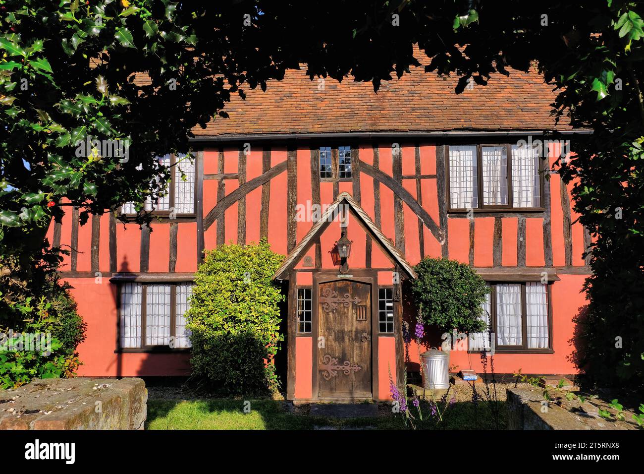 Dedham: Cottage colorato in legno e rami holly subito dopo l'alba a Crown Street nel villaggio di Dedham, Essex, Inghilterra, Regno Unito Foto Stock