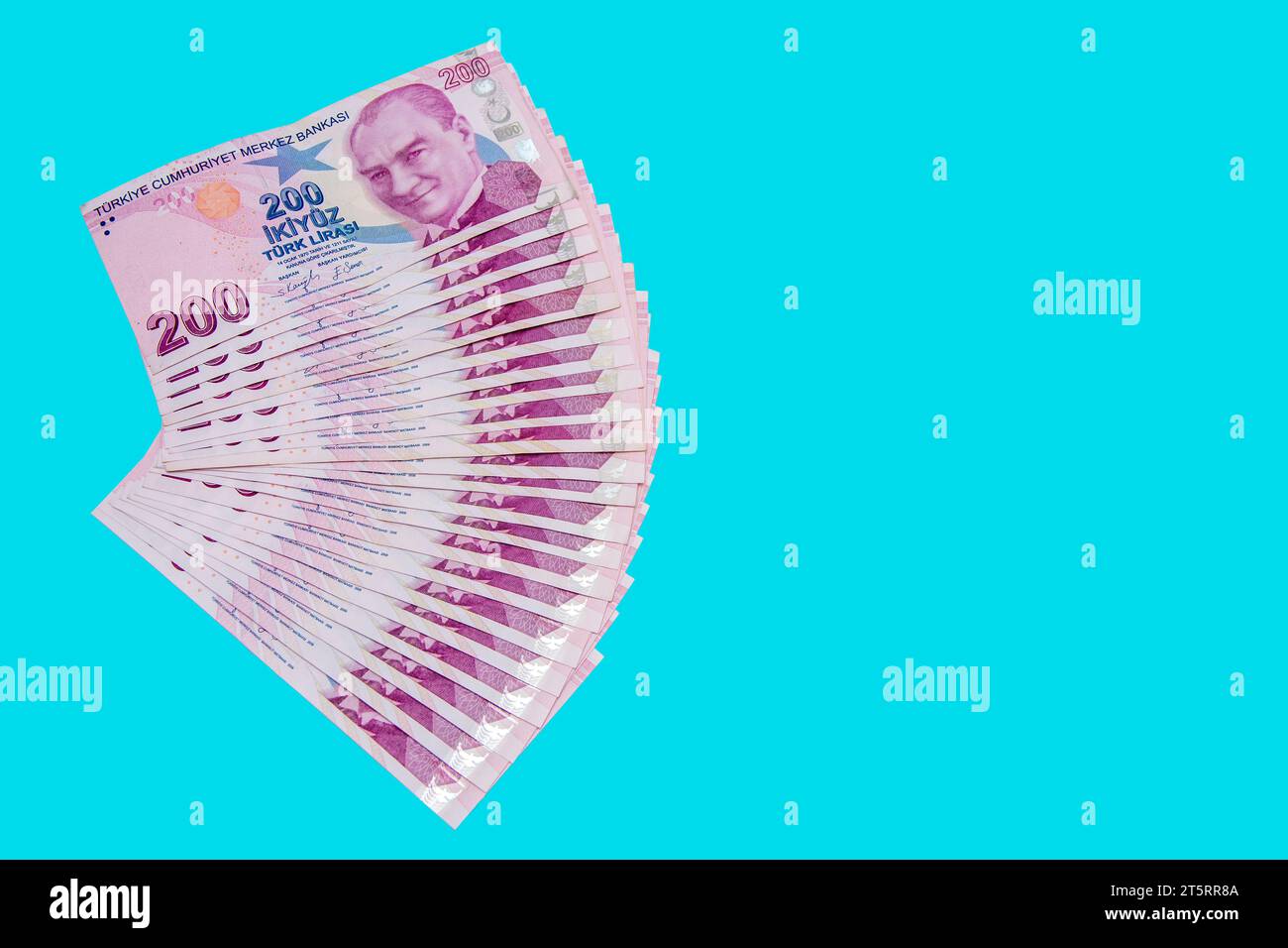 200 lire turche disposte in un quarto di pezzo su sfondo blu Foto Stock