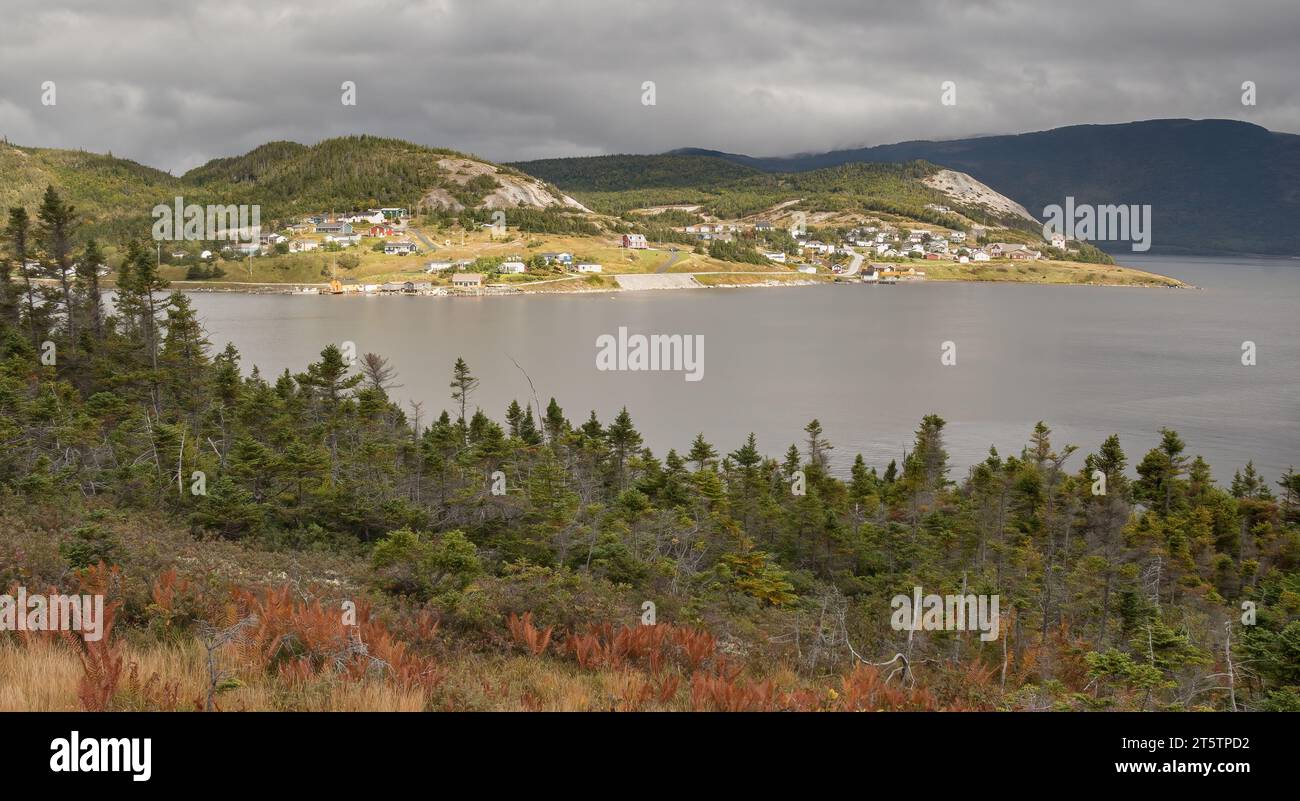 Un piccolo villaggio sulla riva di Bonne Bay Terranova con nuvole scure sulle lontane montagne di Gros Morne Foto Stock