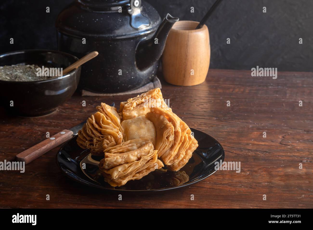 Pastelito argentino accanto a un bollitore, un mate e yerba mate. Foto Stock