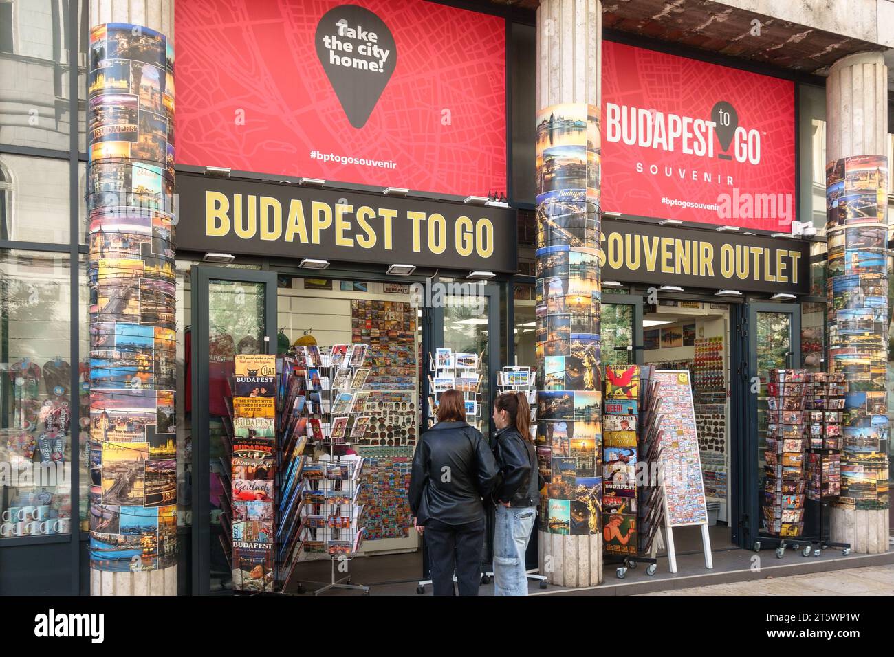 Due donne che guardano i magneti fuori da un negozio di souvenir a Budapest, in Ungheria Foto Stock
