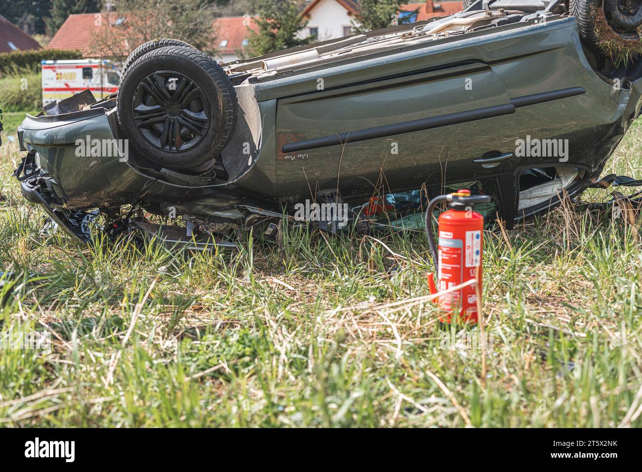 Ein PKW liegt völlig zerstört auf dem Dach, nachdem der Fahrer die Kontrolle über sein Fahrzeug verloren hatte und von der Straße abkam. Die Feuerweh Foto Stock