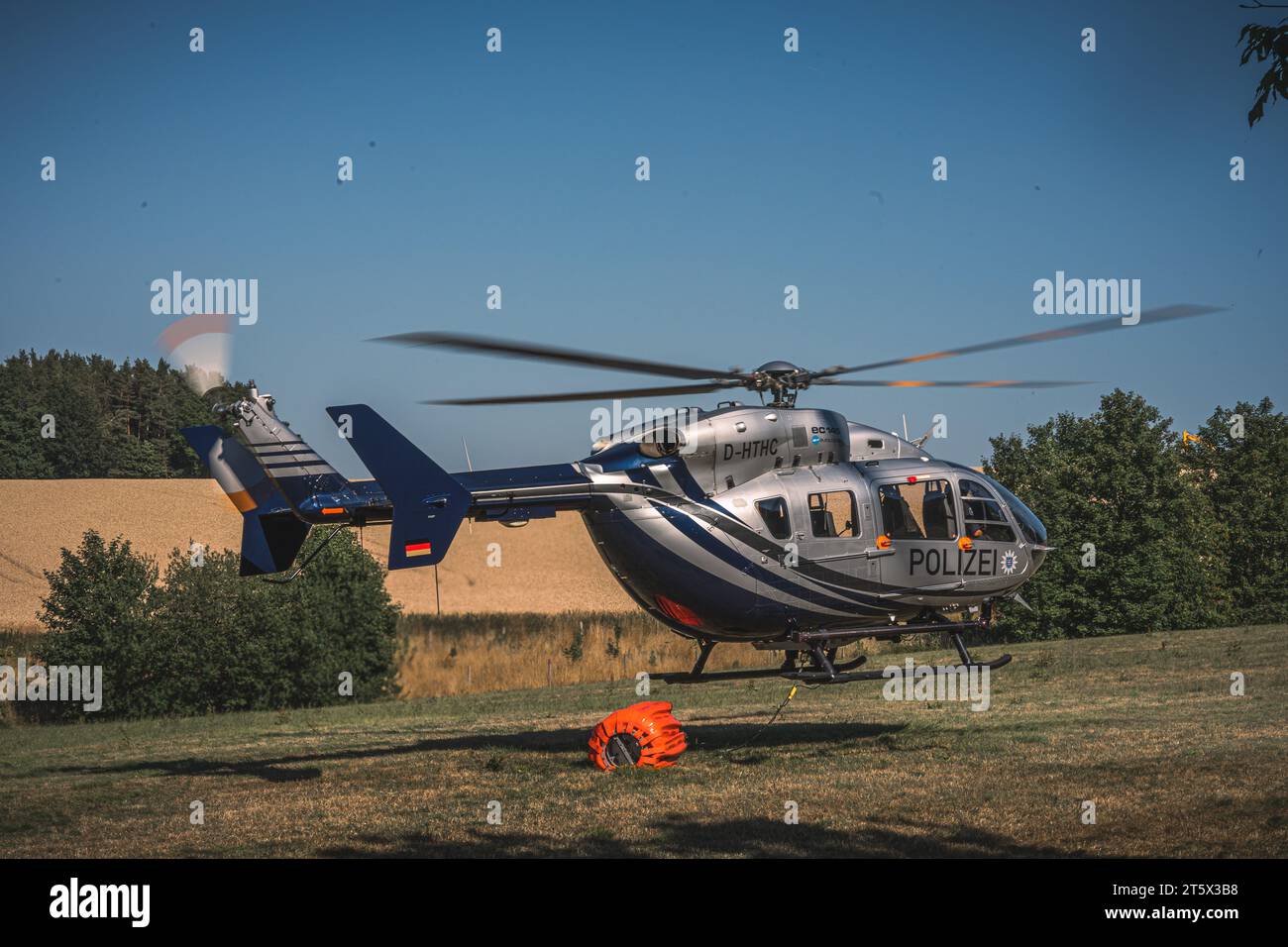 Ein Polizeihubschrauber startet mit angehängtem Löschwasserbehälter, um die Feuerwehr bei einem Wald- und Feldbrand zu unterstützen. AM 19.07.2022 Foto Stock
