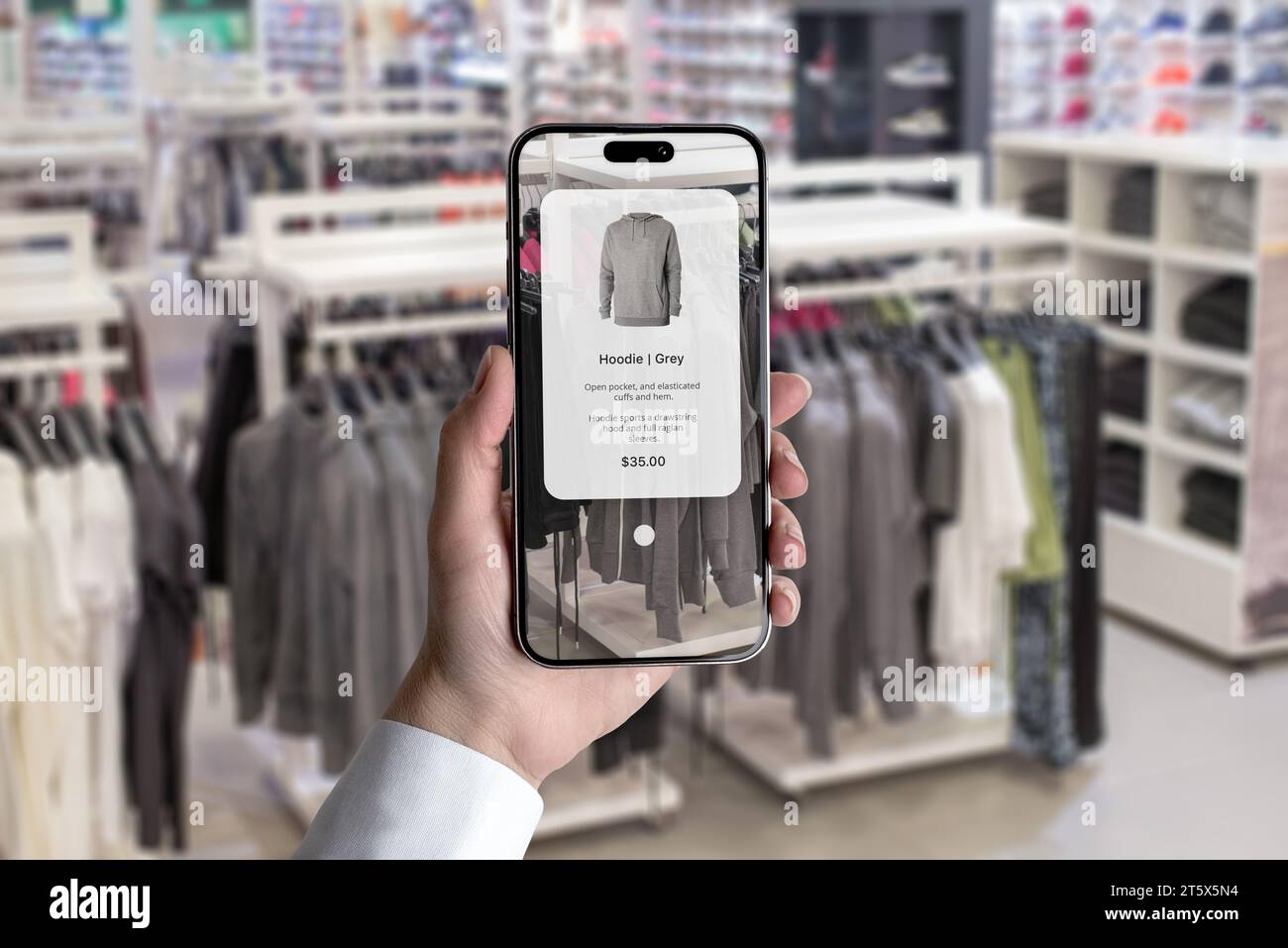 Concetto di futuro dello shopping in negozio di abbigliamento con un'app intelligente. Scopri le caratteristiche degli indumenti puntando semplicemente il telefono Foto Stock