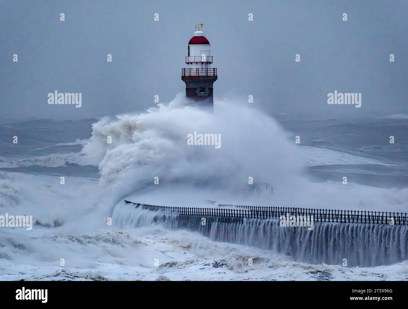 Le enormi onde girano intorno al faro di Roker a Sunderland durante Storm Babet nell'ottobre 2023 Foto Stock