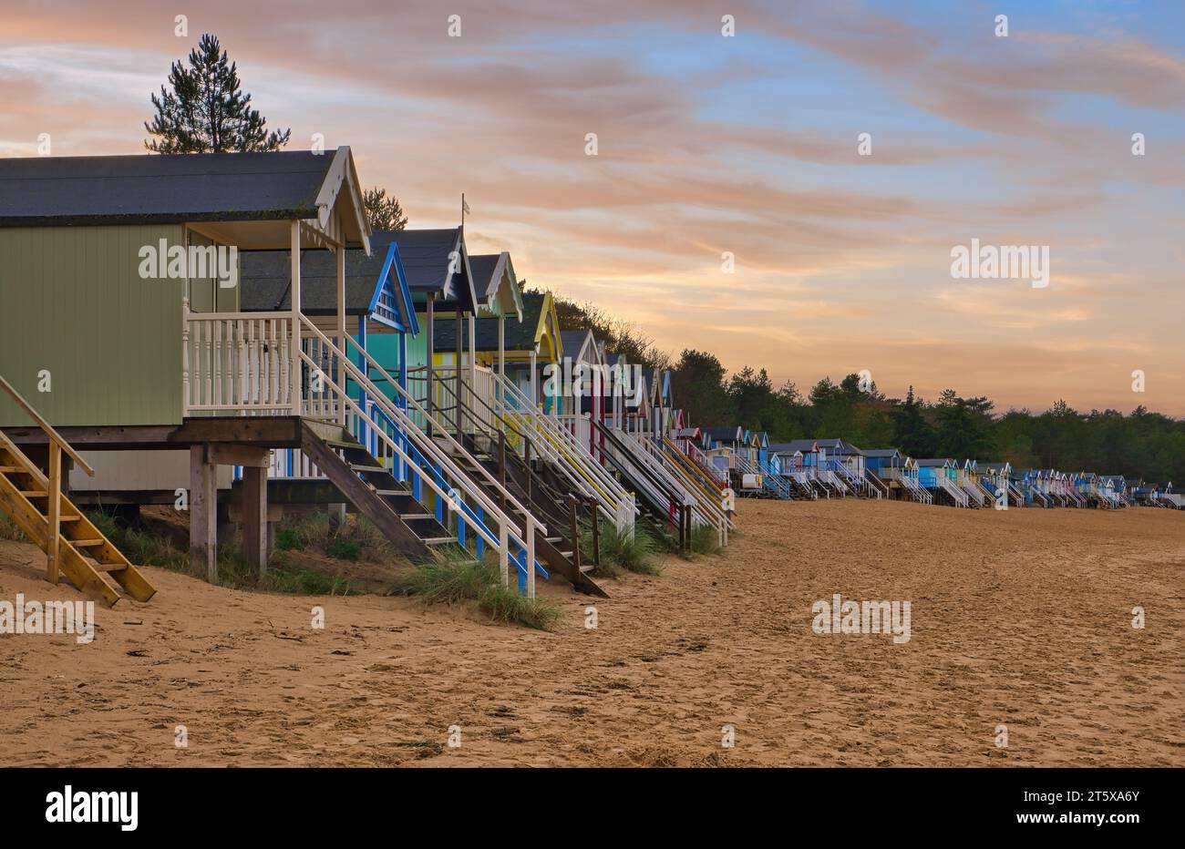 Un bellissimo tramonto invernale sulle iconiche e colorate baite sulla spiaggia di Wells Next the Sea sulla costa del Norfolk settentrionale. Foto Stock