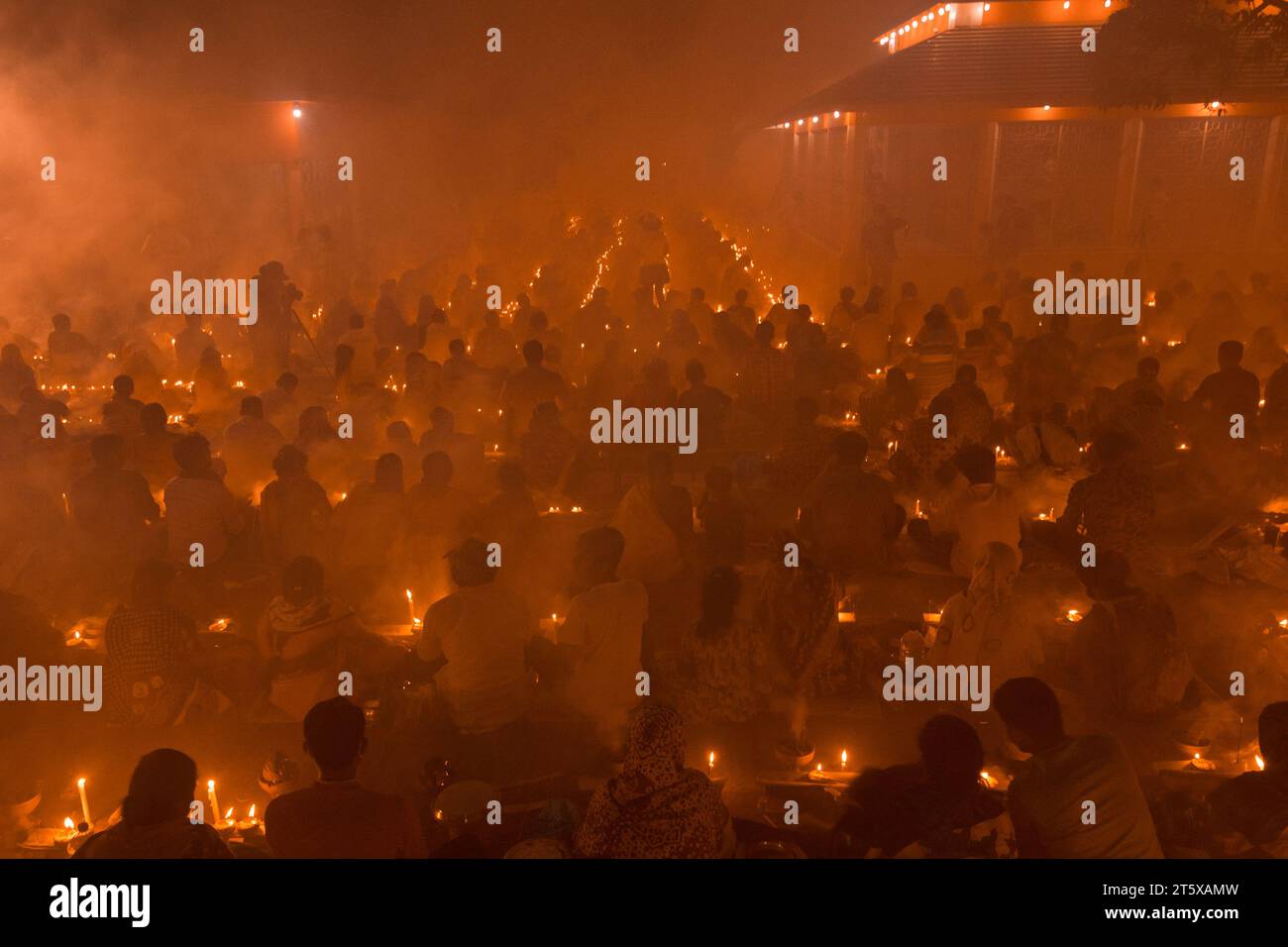 Narayanganj, Bangladesh. 7 novembre 2023. Centinaia di devoti indù si riuniscono di fronte al tempio Shri Shri Loknath Brahmachari Ashram per il Rakher Upobash, un festival religioso di digiuno chiamato Kartik Brati, a Barodi, Narayanganj, Bangladesh. Seduti di fronte alle luci delle candele (localmente chiamate Prodip), essi digiuno e pregano seriamente agli dei per i loro favori durante il rituale. Il festival si tiene ogni sabato e martedì negli ultimi 15 giorni del mese di Bangali - "Kartik. Crediti: Joy Saha/Alamy Live News Foto Stock