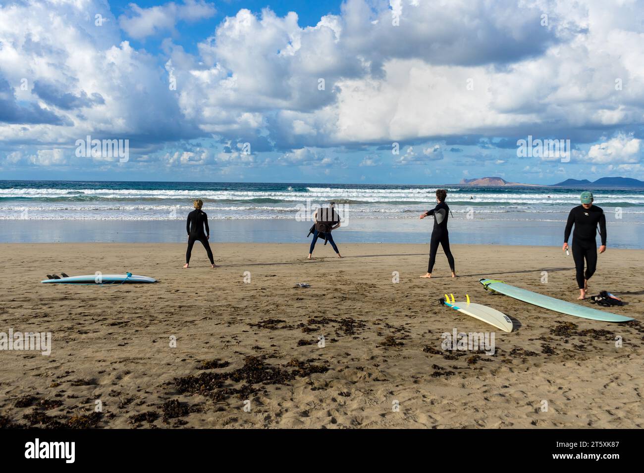 Spagna, Lanzarote, Caleta de Famara: I surfisti si allenano sulla spiaggia di Famara prima di fare surf Foto Stock