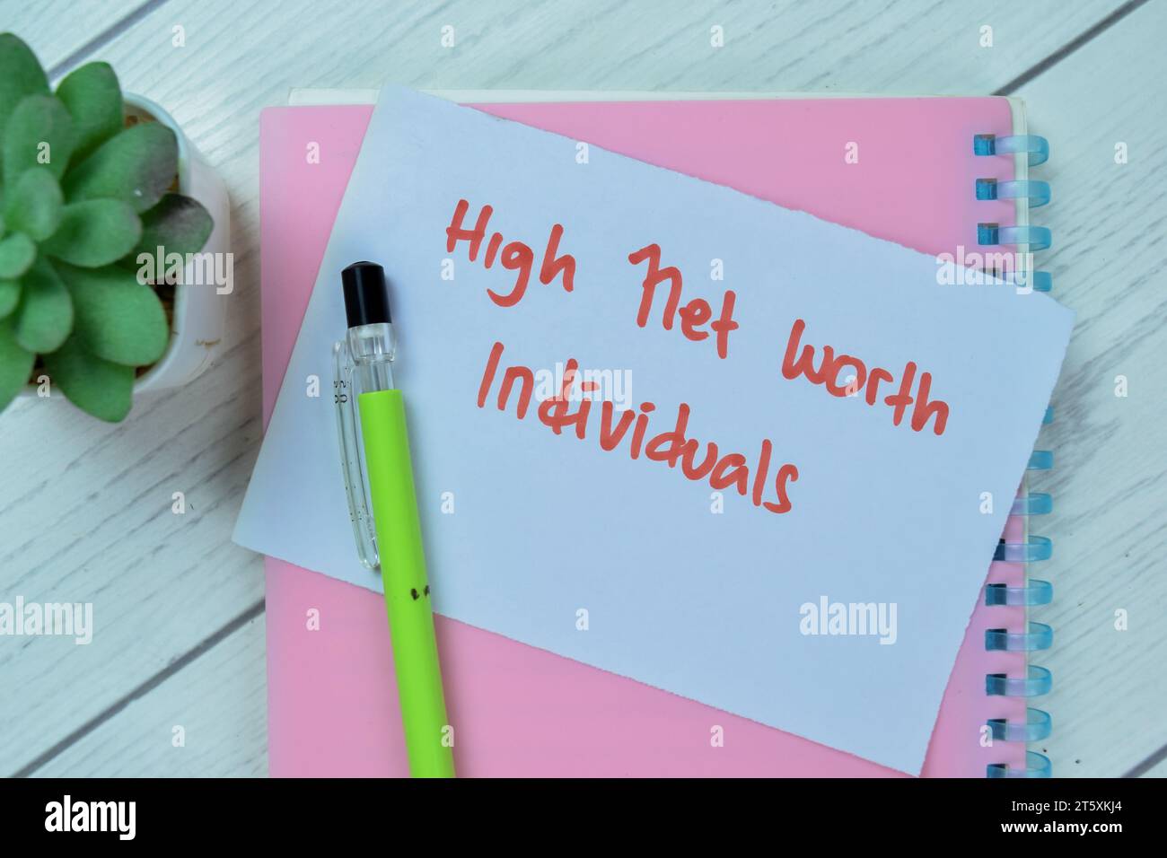 Concetto di High Net Worth Individuals scrivere su appunti isolati su Wooden Table. Foto Stock