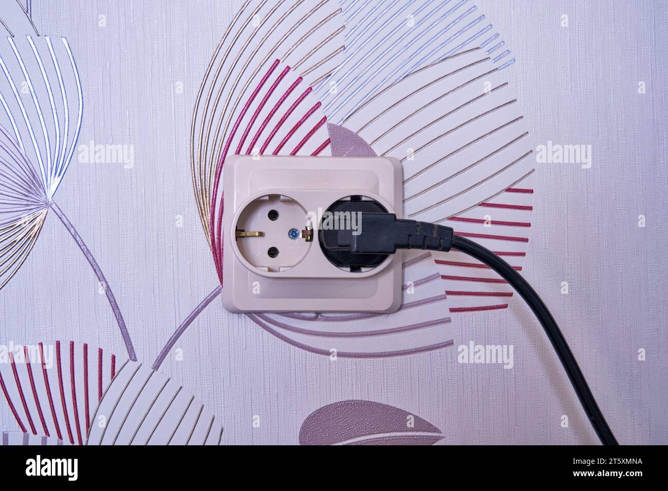 Doppia presa di alimentazione con spina inserita su una parete arancione chiaro, spazio per il testo. Alimentazione elettrica Foto Stock