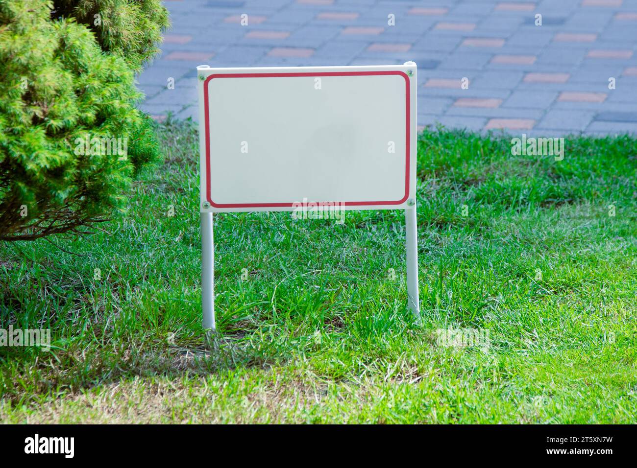 Puntatore sull'erba verde. La disposizione dello striscione con spazio per il testo è vietata, non camminare sul prato, è pericoloso, per la vendita. Layout della bacheca informativa. Spazio copia mockup Foto Stock