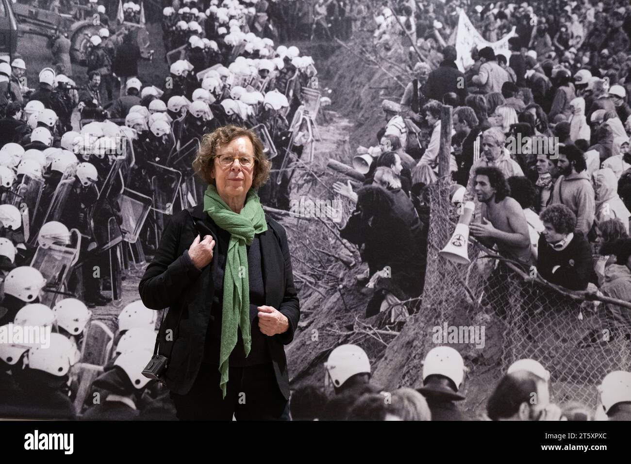 Francoforte, Germania. 7 novembre 2023. 7 novembre 2023, Assia, Francoforte sul meno: La fotografa Barbara Klemm si trova di fronte a una delle sue foto che mostrano gli scontri tra dimostranti e agenti di polizia durante la costruzione della pista ovest durante un'anteprima della sua mostra "Barbara Klemm - Frankfurt Images" presso il Museo Historisches. Foto: Boris Roessler/dpa Credit: dpa Picture Alliance/Alamy Live News Foto Stock