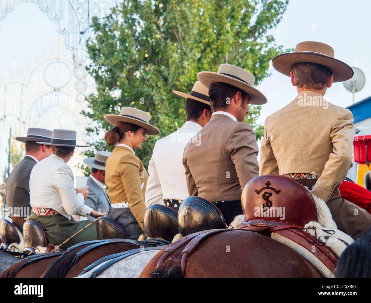 Gruppi di cavalieri vestiti in tipico costume andaluso, cavalcando attraverso la zona fieristica di Fuengirola durante la celebrazione della Feria Foto Stock