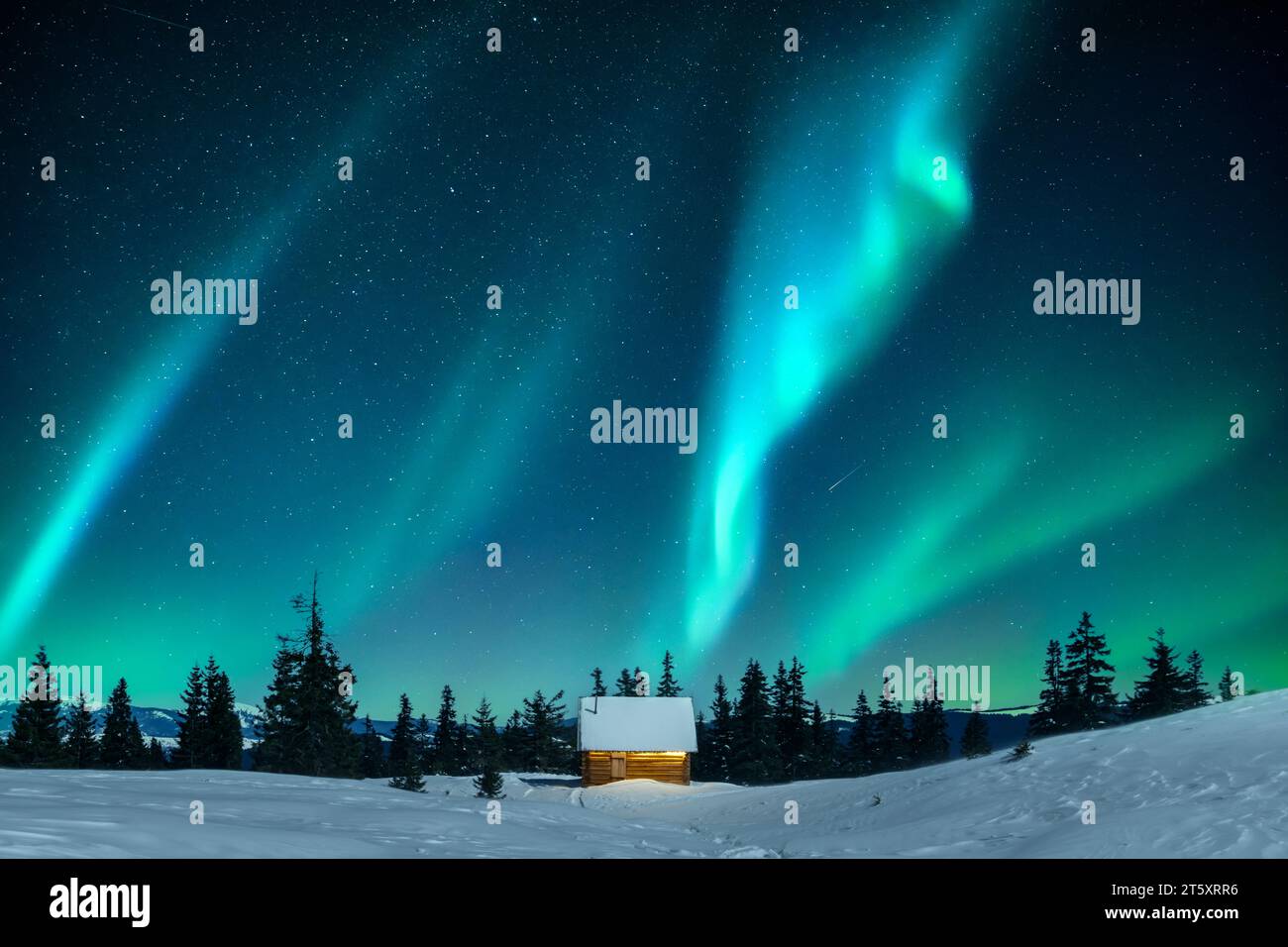 Una capanna annidata tra abeti innevati su una radura di montagna in inverno. Aurora boreale. Aurora boreale nella foresta invernale. Concetto di vacanze natalizie e vacanze invernali Foto Stock