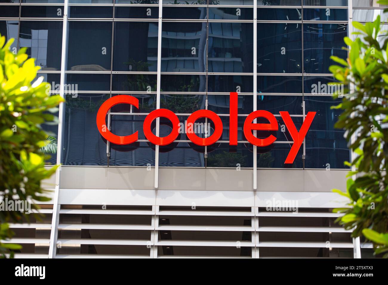 Cartellonistica per servizi aziendali dello studio legale Cooley di colore rosso attaccata alla facciata di un edificio commerciale, Singapore. Foto Stock