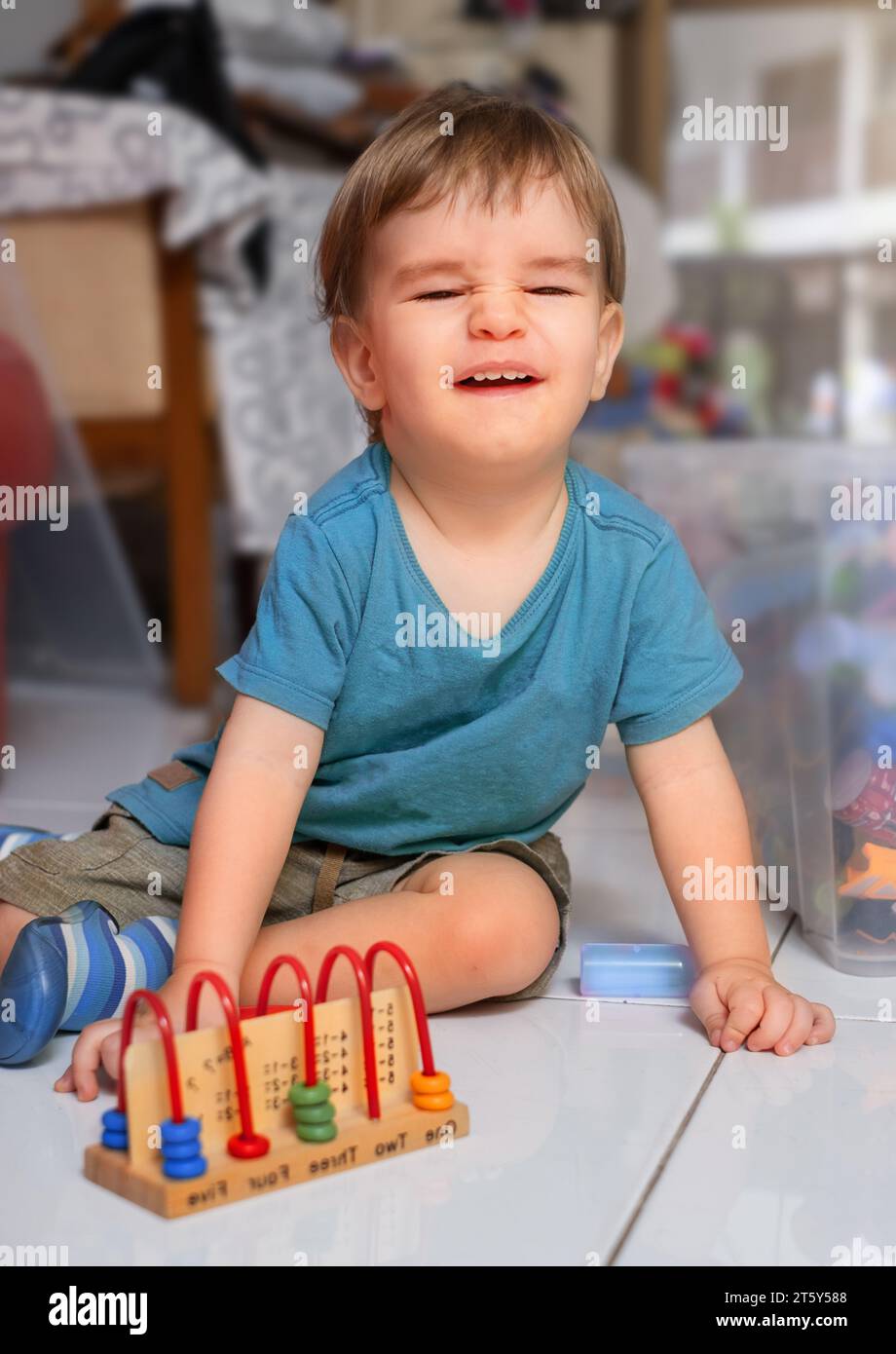 Il bambino ride mentre gioca a un gioco educativo per contare Foto Stock