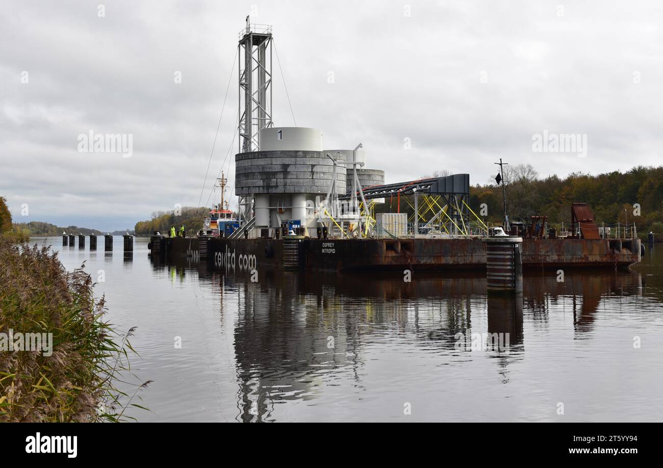 Rimorchiatore che traina un pontone con installazione offshore nel canale di Kiel, Schleswig-Holstein, Germania Foto Stock