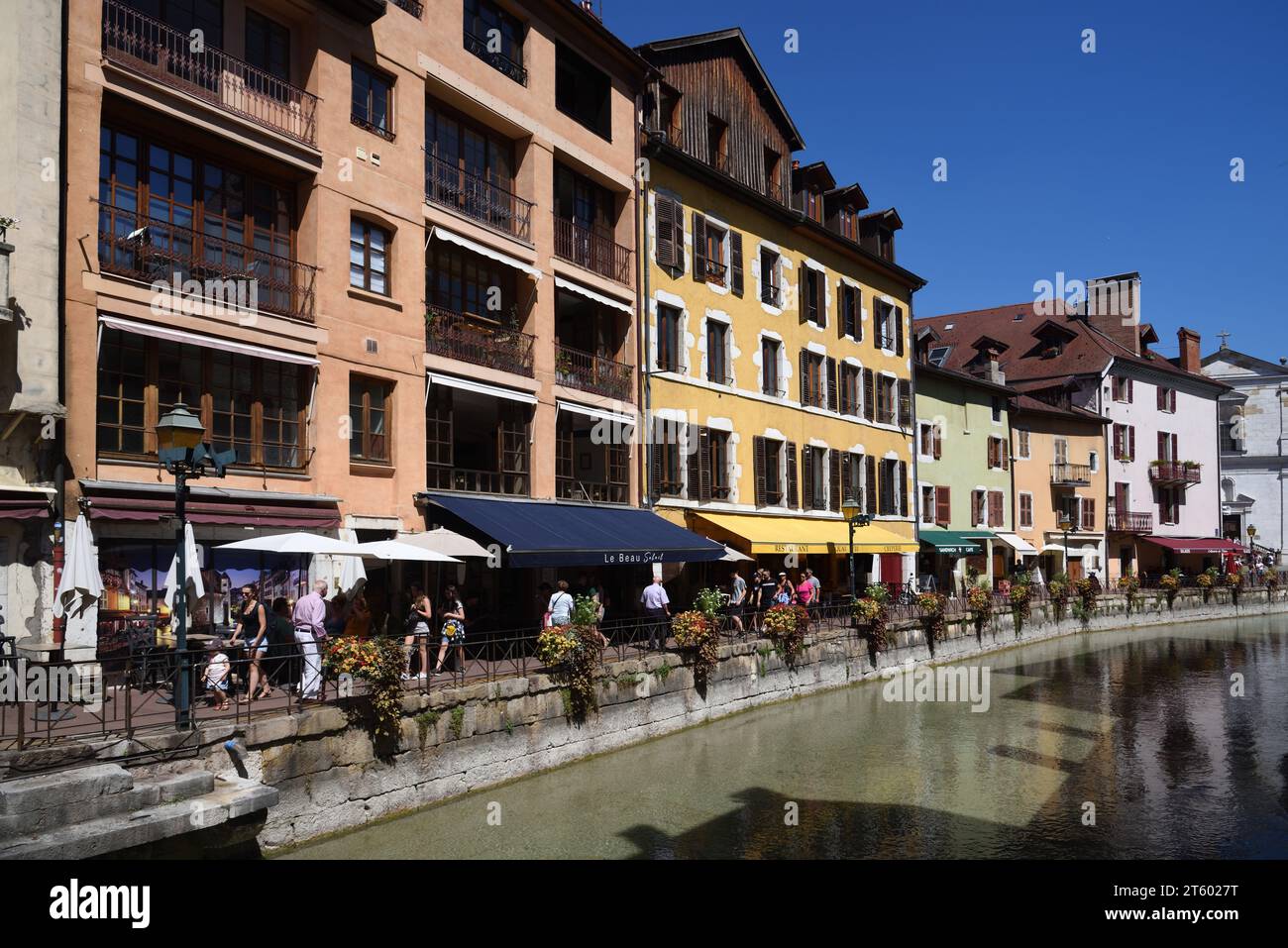 I turisti camminano lungo Quay, Quayside, Quai Perrière o Walkway lungo il fiume le Thiou nel centro storico di Annecy, alta Savoia, Francia Foto Stock